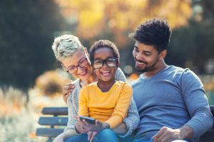 Family of different races with on a park bench