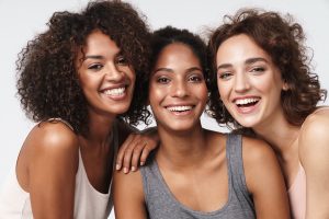 Three ladies with different types of curly hair and different skin complexions