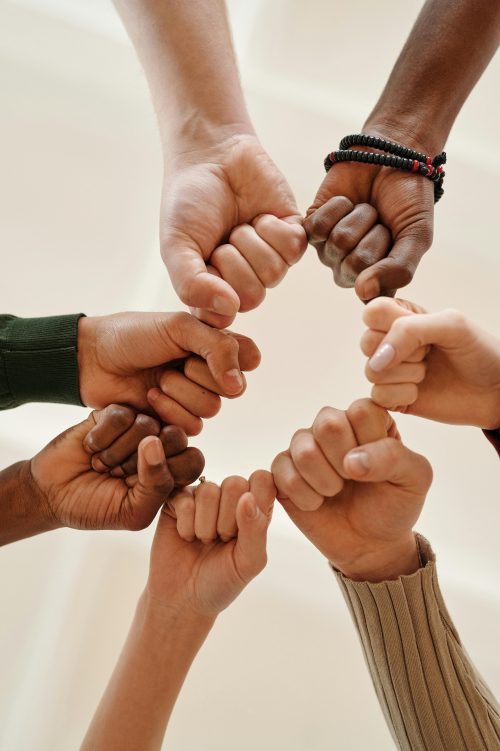 Seven fists form a circle, representing people from different races uniting and overcoming racial bias together